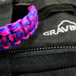 Bracelet de survie en paracorde tressée fuchsia et bleu électrique avec boucle à clip Gravipack®