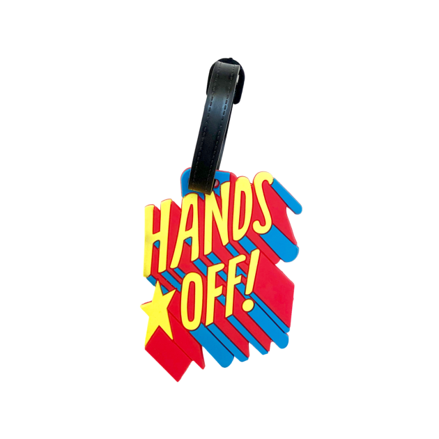 Porte-nom Gravipack « Hands Off » visible avec flash sur la face avant d’une valise